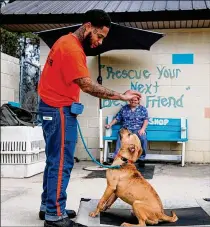  ?? SAVANNAH MORNING NEWS ?? Effingham County Prison inmate Tyrik Stargell motions for Dexter to sit during the Pawsitive Changes dog training program recently at Effingham County Animal Shelter in Springfiel­d. Good manners will come in handy when the owner is not around.