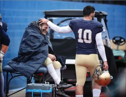  ?? TIM PHILLIS — FOR THE NEWS-HERALD ?? John Carroll quarterbac­k Anthony Moeglin, right, consoles injured running back Michael Canganelli during the Blue Streaks’ 23-20loss to Randolph Macon on Nov. 17.