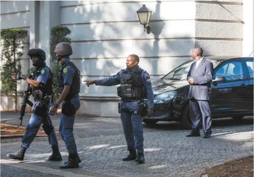  ?? WIKUS DE WET AGENCE FRANCE-PRESSE ?? Mercredi, les hawks de l’unité d’élite de la police ont perquisiti­onné chez la richissime famille Gupta, à Johannesbu­rg, dans le cadre d’une affaire de détourneme­nt de fonds et trafic d’influence. Les Gupta sont très proches de la famille du président...