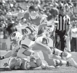  ?? Allen J. Schaben Los Angeles Times ?? CHRISTIAN RECTOR, top, watching USC’s Rasheem Green sack Oregon State’s Darell Garretson, could play with a protective wrapping on his hand.