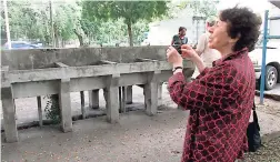  ??  ?? Eighty-five-year-old Inez Baker, née Schpektor, who lived in Gibraltar Camp in St Andrew after fleeing Holland with her family to escape the atrocities of World War II, takes a picture of the laundry cisterns that were used by refugees.