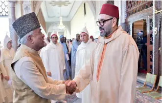  ??  ?? Le Roi Mohammed VI saluant un des conférenci­ers des « Al Dourouss Al Hassanya ».