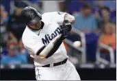  ?? WILFREDO LEE — THE ASSOCIATED PRESS ?? The Marlins' Jesus Aguilar hits a single during the first inning against the Mariners on Saturday in Miami.