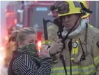  ??  ?? A local resident speaks with a firefighte­r stationed along the Pacific Coast Highway to battle the Woolsey fire, which stretches 21 miles along the coast, in Malibu, Calif., on Friday.