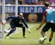  ?? ASSOCIATED PRESS PHOTO ?? United States goalkeeper Tim Howard, left, defends against teammate Brad Davis during a scrimmage at the team’s open workout, Saturday in Harrison, N.J.