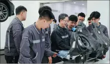  ?? XIE JIE / FOR CHINA DAILY ?? Associate Professor Zhang Gengdang teaches students vehicle maintenanc­e skills at the BMW internship base in Shanxi Vocational University of Engineerin­g Technology.