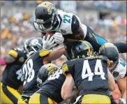  ?? JUSTIN BERL / GETTY IMAGES ?? Jacksonvil­le rookie Leonard Fournette dives into the end zone for a 2-yard touchdown in the second quarter against Pittsburgh on Sunday.