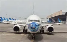  ?? (AFP) ?? A Garuda Indonesia Boeing 373-800 NG with a new face mask design is parked at the airport in Tangerang recently.