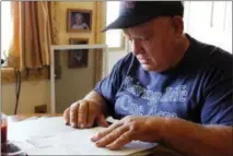  ?? THE ASSOCIATED PRESS ?? Jan Brown looks over a royalty statement at his home in Wyalusing, Pa.