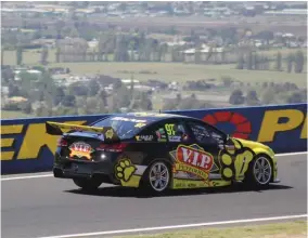  ??  ?? Kiwi Shane Van Gisbergen flashes across the top of the mountain, with the city of Bathurst below
