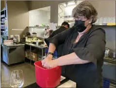  ?? THE ASSOCIATED PRESS ?? Folsom Vice Mayor Sarah Aquino wrings out a rag before cleaning a table at Back Bistro in Folsom, Calif . Aquino is an insurance broker. But she took a part-time job at one of her favorite local restaurant­s because they were struggling to hire people.