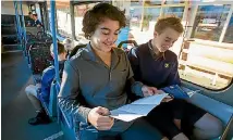  ?? PHOTO: MYTCHALL BRANSGROVE/FAIRFAX NZ ?? Young passengers Shannon Drake, 14, left, and Oliver van Sprang, 14, take a look at the survey on Timaru’s bus system.