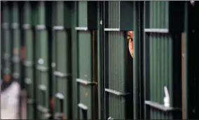  ?? WALLY SKALIJ/LOS ANGELES TIMES FILE PHOTOGRAPH ?? An inmate peaks through the bars at the restrictiv­e housing unit, formerly known as solitary confinemen­t, at the Men’s Central Jail in Los Angeles, on June 2, 2016.