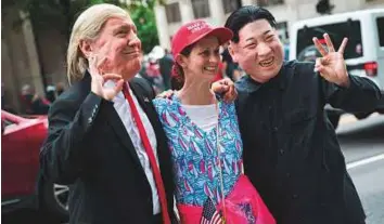  ?? AFP ?? A supporter of US President Donald Trump poses for photos with people dressed as President Trump and North Korean leader Kim Jong-un before a rally in Nashville, Tennessee.