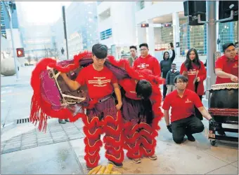  ?? [SARAH PHIPPS PHOTOS/THE OKLAHOMAN] ?? St. Andrew Dung Lac Lion Dance Associatio­n members Daniel Ngo and Nhat Le bow prepare to perform at Park Harvey Sushi in downtown Oklahoma City.