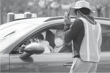  ?? JOE CAVARETTA/SOUTH FLORIDASUN SENTINEL ?? People drive up in cars Tuesday at a COVID-19 vaccinatio­n event at Broward Central Regional Park in Lauderhill.