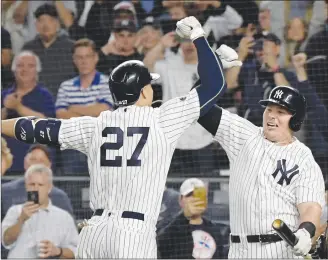  ?? AP PHOTO ?? New York Yankees’ Giancarlo Stanton (27) celebrates with Luke Voit after hitting a solo home run against the Oakland Athletics during the eighth inning of the American League wild-card playoff baseball game Wednesday in New York.