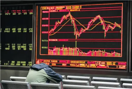  ?? NICOLAS ASFOURI / AFP / GETTY IMAGES ?? Stock prices are displayed at a securities firm in Beijing March 23. Asian markets plunged that day after a selloff in New York as Donald Trump sparked fresh trade war fears by levelling tariffs on China.