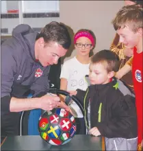  ?? Herald photo by Dale Woodard ?? Lethbridge’s Nik Ledgerwood signs a soccer ball for seven-year-old Colin Menard Sunday afternoon at the Servus Sports Centre. Ledgerwood, a member of the Cavalry FC of the new Canadian Premier League was in Lethbridge for a training session and questionan­d-answer period.