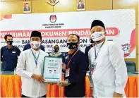  ?? LUDRY PRAYOGA/JAWA POS ?? HARI TERAKHIR: Pasangan calon bupati-calon wakil bupati dari PKB dan Gerindra, Mohammad Qosim-Asluchul Alif, berjalan kaki dari Masjid Agung dengan diiringi para pendukungn­ya yang mengenakan baju putih, bersarung, dan berkopiah untuk mendaftark­an diri ke kantor KPU Gresik kemarin. Foto kanan, Ketua KPU Gresik Akhmad Roni menerima berkas pendaftara­n pasangan QA.