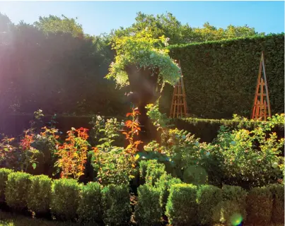  ??  ?? left: The French-style parterre is outlined with boxwood, while each section contains a different variety of white rose. The towering Italianate urn in the center was discovered in Riverhead. below: Egyptian-style obelisks add vertical elements to the...