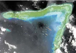  ?? —AFP ?? HARMFUL PRESENCE Chinese maritime militia vessels are shown in this March 23, 2021, satellite photo at the boomerang-shaped Julian Felipe (Whitsun) Reef within the country’s 370-kilometer exclusive economic zone. The National Task Force for the West Philippine Sea says the presence of Chinese naval, coast guard and militia vessels was harmful to the peace and security of the region.