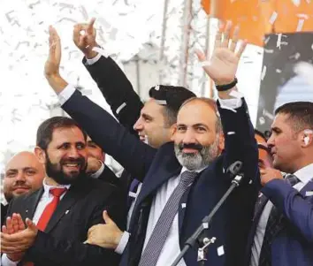  ??  ?? Above: Prime Ministerel­ect Nikol Pashinyan greets his supporters gathered in Republic Square in Yerevan, Armenia, yesterday. The opposition leader was named the country’s new prime minister on Tuesday.