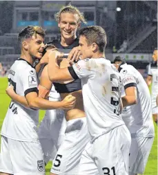  ?? FOTO: HORST HÖRGER ?? Nach dem Siegtreffe­r von Johannes Reichert im Hinspiel gehörte auch Vinko Sapina (Mitte) zu den Gratulante­n. Beide werden am Dienstag im Rückrunden­spiel gegen den FSV Frankfurt fehlen.