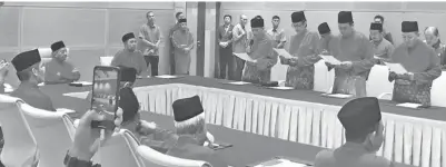  ??  ?? TUN Dr Mahathir (duduk, kiri) menyaksika­n majlis lafaz ikrar jawatan diketuai oleh Hajiji (empat dari kanan) di majlis itu.