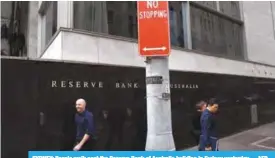  ??  ?? SYDNEY: People walk past the Reserve Bank of Australia building in Sydney yesterday. —AFP