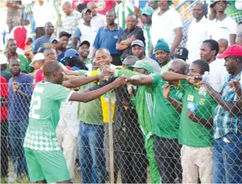  ??  ?? STAR ATTRACTION ... CAPS United striker John Zhuwawu is congratula­ted by the Green Machine fans at the end of the match at Hartsfield yesterday after scoring the goal that earned the champions a point — (Picture by Paul Mundandi)