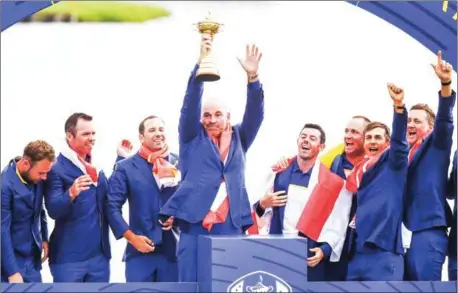  ?? FRANCK FIFE/AFP ?? Europe’s Danish captain Thomas Bjorn raises the trophy flanked by his team as they celebrate winning the 42nd Ryder Cup at Le Golf National Course at Saint-Quentin-en-Yvelines, southwest of Paris, on Sunday.