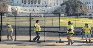  ?? REUTERS ?? Workers install a fence in front of the U.S. Capitol in Washington on Wednesday, a day after supporters of U.S. President Donald Trump occupied the Capitol Building.