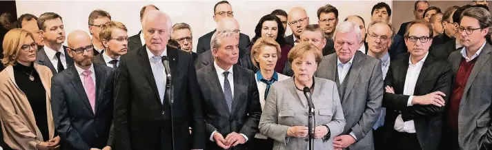 ?? FOTO: DPA ?? Ringen um Erklärunge­n: In der Nacht zu gestern traten die CDU-Vorsitzend­e Angela Merkel und CSU-Chef Horst Seehofer gemeinsam an die Mikros. Ihre Parteigrem­ien standen buchstäbli­ch geschlosse­n hinter ihnen.