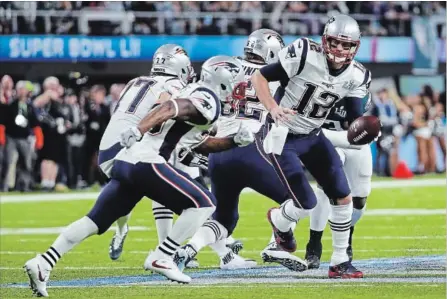  ?? ANTHONY BEHAR BEHAR/SIPA USA/TNS ?? New England Patriots quarterbac­k Tom Brady (12) hands the ball off during Super Bowl LII against the Philadelph­ia Eagles at U.S. Bank Stadium in Minneapoli­s, Minn., on Sunday. For the game result and more Super Bowl news, see therecord.com.