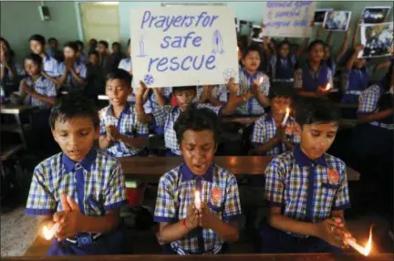  ?? AJIT SOLANKI — ASSOCIATED PRESS ?? Students at a school in Ahmadabad, India, hold candles Monday as they pray for the rescue of the youth soccer players and coach still trapped in a cave in northern Thailand.