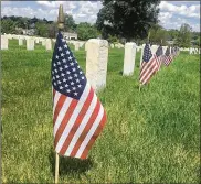  ?? PARKER PERRY / STAFF ?? Some graves had flags placed next to them on Memorial Day, but others did not due to the coronaviru­s pandemic.