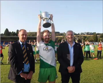  ??  ?? Baltinglas­s captain Kevin Murphy lifts the Miley Cup with Wicklow GAA Chairman Martin Fitzgerald and sponsor Fergal Donoghue of Boom & Platform Hire.