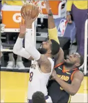  ?? Luis Sinco Los Angeles Times ?? MARKIEFF MORRIS goes hard to the hoop against the Warriors’ Kevon Looney in the seccond quarter.