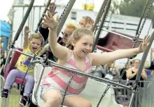  ??  ?? Children react to a ride on a giant swing.