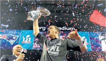  ?? GETTY IMAGES ?? New England quarterbac­k Tom Brady raises the Vince Lombardi Trophy after leading an improbable comeback to defeat the Atlanta Falcons during Super Bowl 51 in February. Down 28- 3 at one point, the Patriots ended up winning 34- 28.