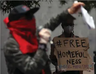  ?? PHOTOS BY ARIC CRABB — STAFF PHOTOGRAPH­ER ?? Housing activist Lisa Gray-Garcia, left, takes part in a rally to support project “Homefulnes­s” on Tuesday in Oakland. The city has waived a $40,000impact fee that was preventing people from moving in.