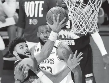  ?? MIKE EHRMANN GETTY IMAGES ?? The Nuggets’ Jamal Murray, who had 28 points and 12 assists, drives to the basket in the third quarter.