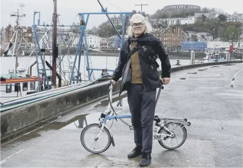  ??  ?? Millionair­e Roc Sandford in Oban en route to Gometra – but forget luxury cars and helicopter­s, he uses public transport and a bike