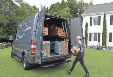  ?? TED S. WARREN/AP FILE ?? Parisa Sadrzadeh, a senior manager of logistics for Amazon.com, demonstrat­es a package delivery for journalist­s at a media event in Seattle to announce a new program that lets entreprene­urs around the country launch businesses that deliver Amazon...