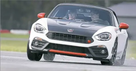  ?? Elizabeth Robertson/Philadelph­ia Inquirer ?? In a Fiat 124 Spider Abarth, Skip Barber Racing School instructor Don Kutschall guides Scott Sturgis around the skidpad at the New Jersey Motorsport­s Park in Millville, N.J.