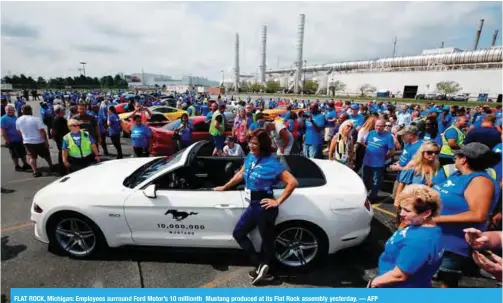  ??  ?? FLAT ROCK, Michigan: Employees surround Ford Motor’s 10 millionth Mustang produced at its Flat Rock assembly yesterday. — AFP