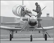  ?? Arkansas Democrat-Gazette/STATON BREIDENTHA­L ?? A pilot exits his T-6 Texan Navy trainer after landing Tuesday at Bill and Hillary Clinton National Airport/Adams Field. Dozens of the planes were flown in from north of Pensacola to escape Hurricane Michael.