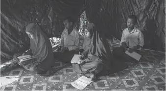  ??  ?? A neighbour allowed Ayan Abdi to stay in one of her huts because the young woman’s mother and siblings returned to Somalia. Ayan returns the favour by tutoring the neighbour’s children.