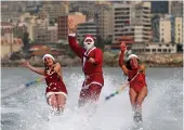  ?? — AFP ?? Members of a Lebanese water ski club perform dressed in Santa Claus outfits in the bay of Jounieh on Friday.